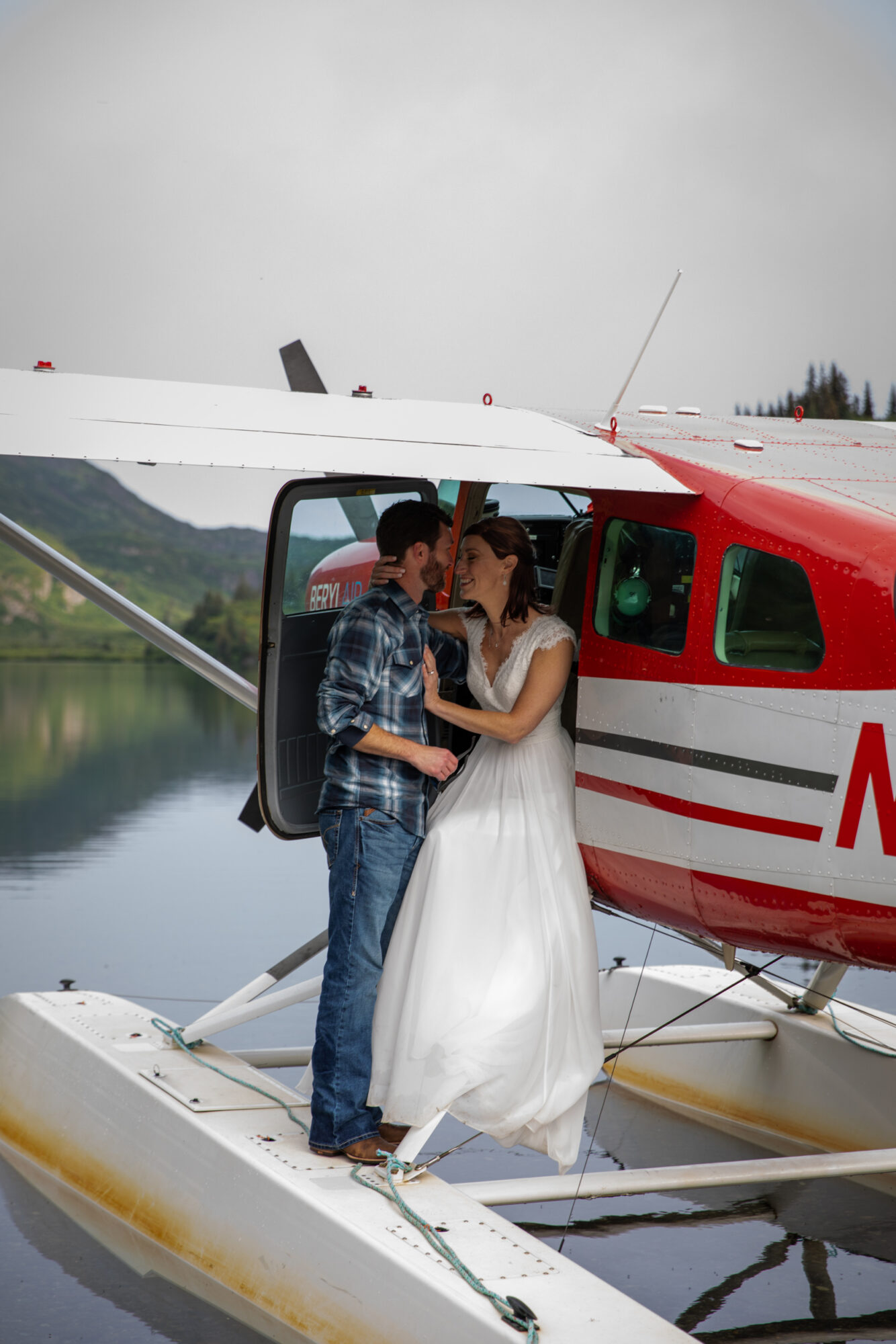 couple sharing a kiss on a floatplane during their Alaska floatplane elopement in a remote mountain setting