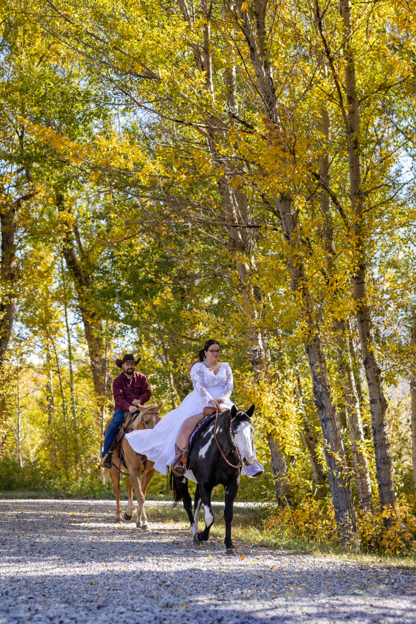 A Loveland Pass Elopement in Colorado: Horseback Riding and a Mountain Wedding | Scenic Vows Couple horseback riding through fall trees during a Loveland Pass elopement in Colorado