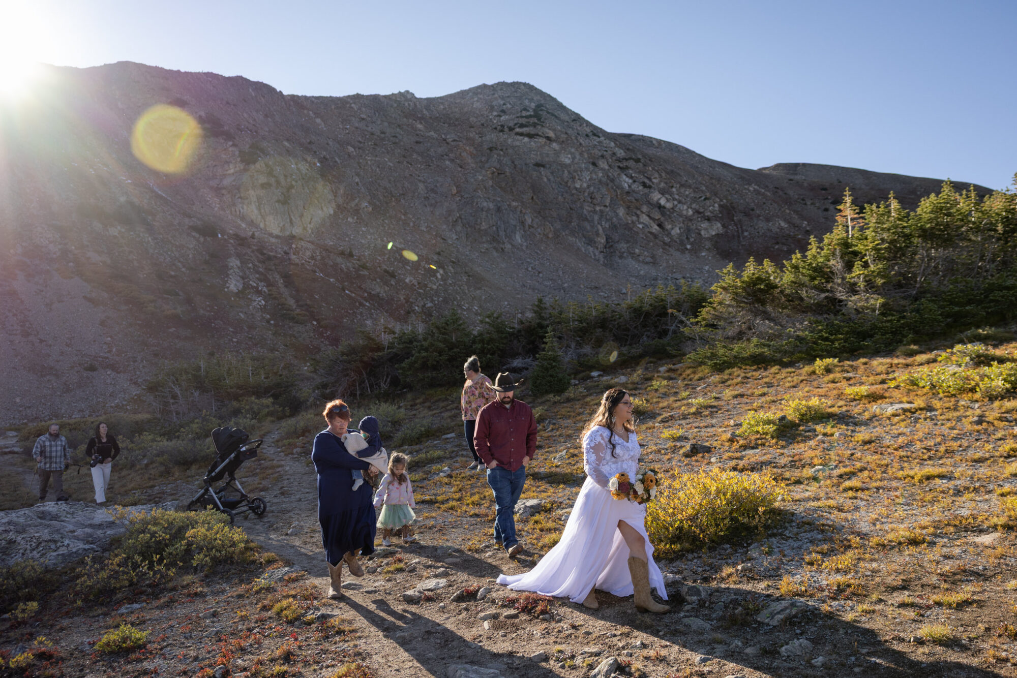A Loveland Pass Elopement in Colorado: Horseback Riding and a Mountain Wedding | Scenic Vows Couple and family walking through alpine terrain during an intimate mountain wedding in Colorado