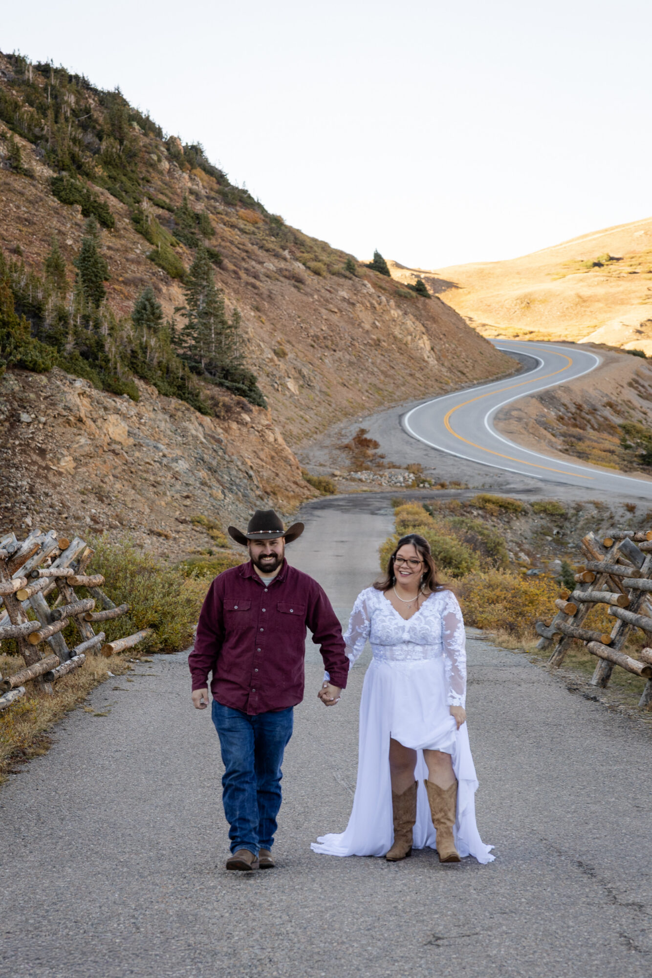 A Loveland Pass Elopement in Colorado: Horseback Riding and a Mountain Wedding | Scenic Vows Couple walking on mountain road after Loveland Pass elopement in Colorado