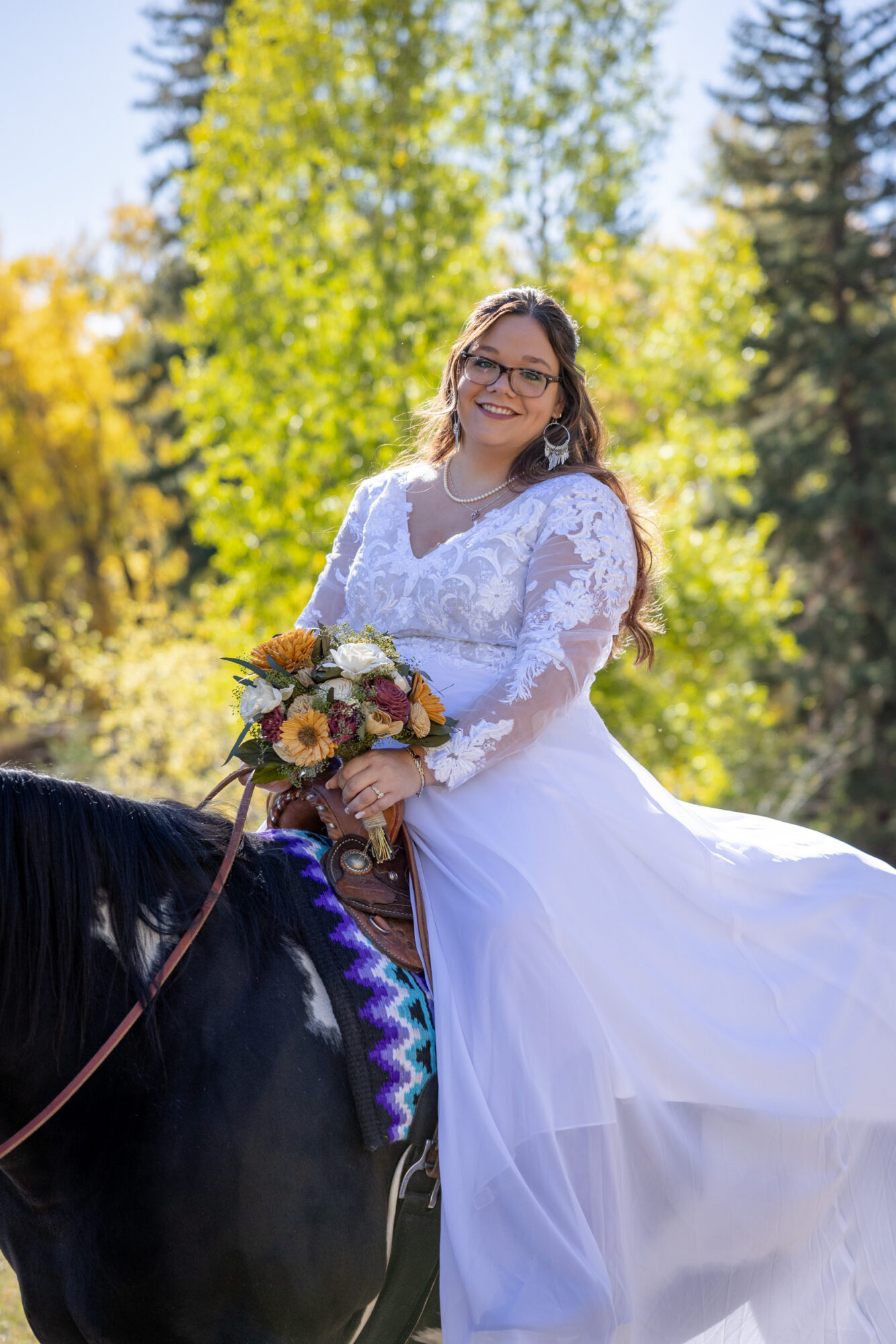 A Loveland Pass Elopement in Colorado: Horseback Riding and a Mountain Wedding | Scenic Vows Bride riding a horse during a Loveland Pass elopement in Colorado with fall mountain scenery