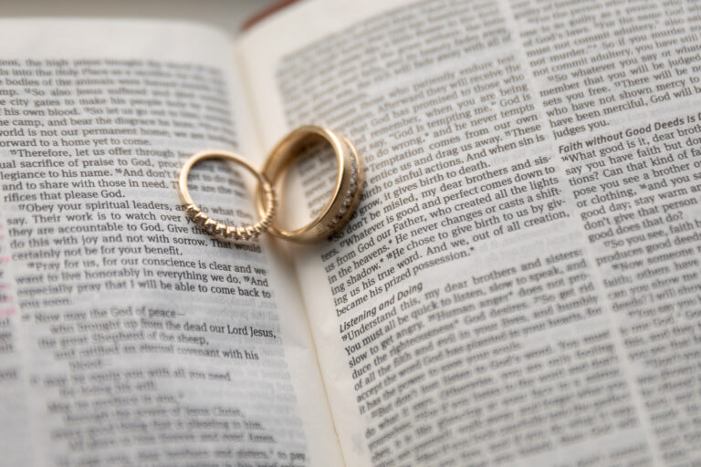 Wedding rings sit inside a Bible.