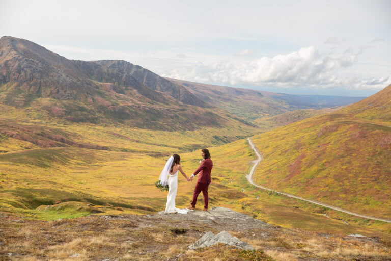 Newlywed stand holding hands and looking at each other after their Hatcher Pass Elopement.