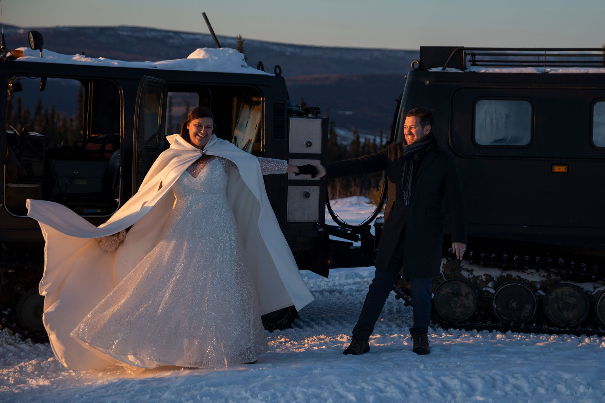 A bride and groom dance together next to a snowcat in Fairbanks Alaska. 