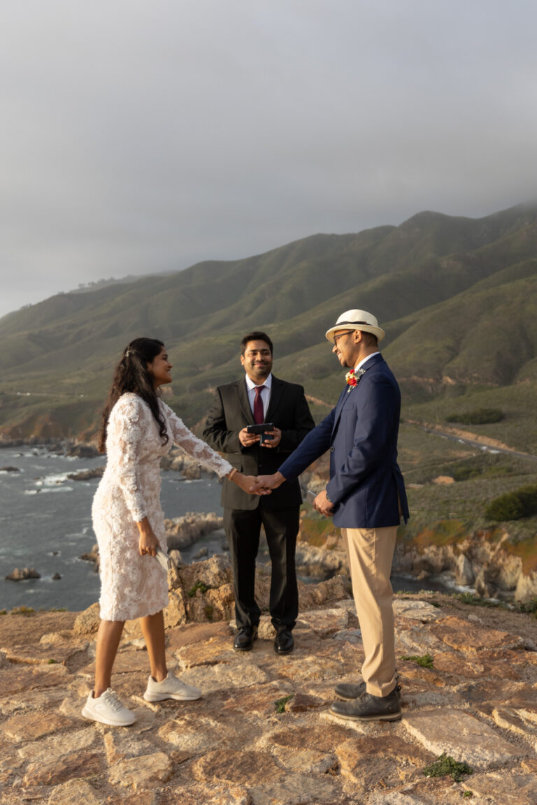 A bride and groom hold hands during their cliffside wedding in Big Sur.