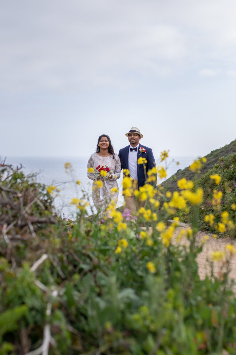 A bride and groom walk up a path on their cliffside wedding day in Big Sur