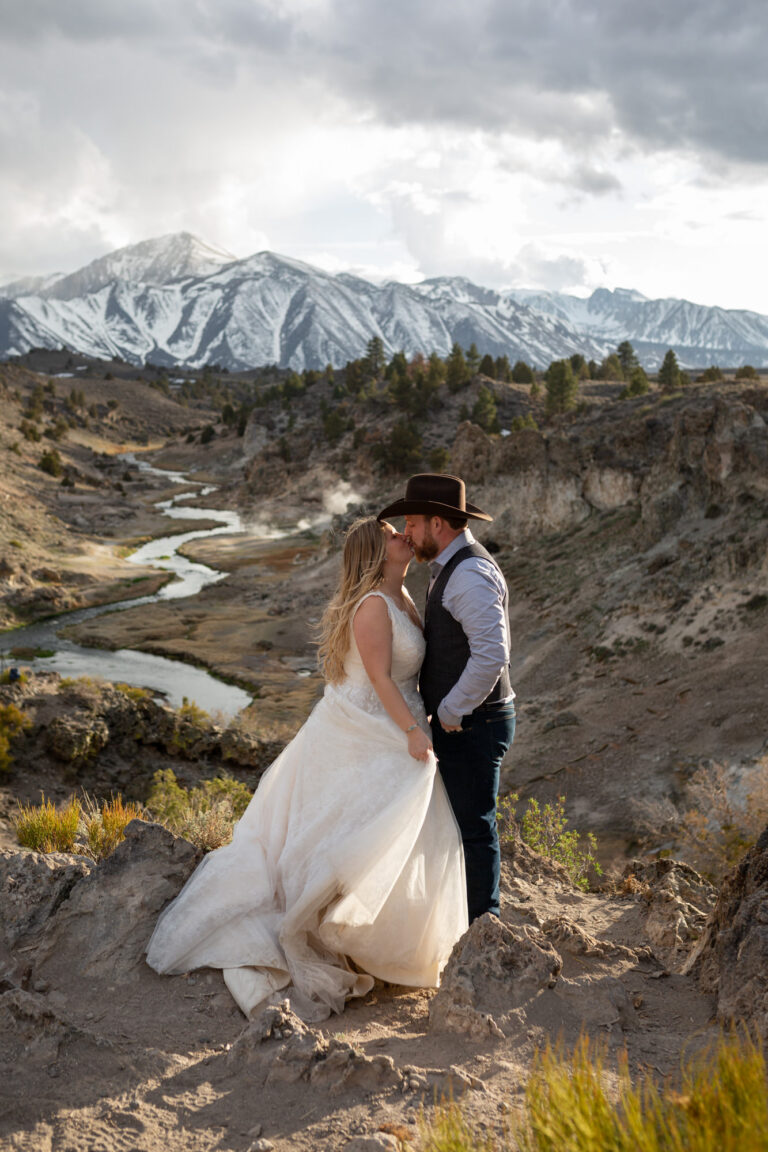 A bride and groom kiss as the sun starts to set on their Convict Lake wedding day.