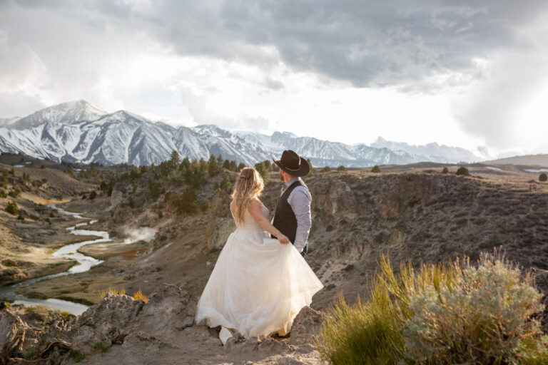 A bride and groom stare at the mountains as the sun starts to set on their Convict Lake Wedding day.
