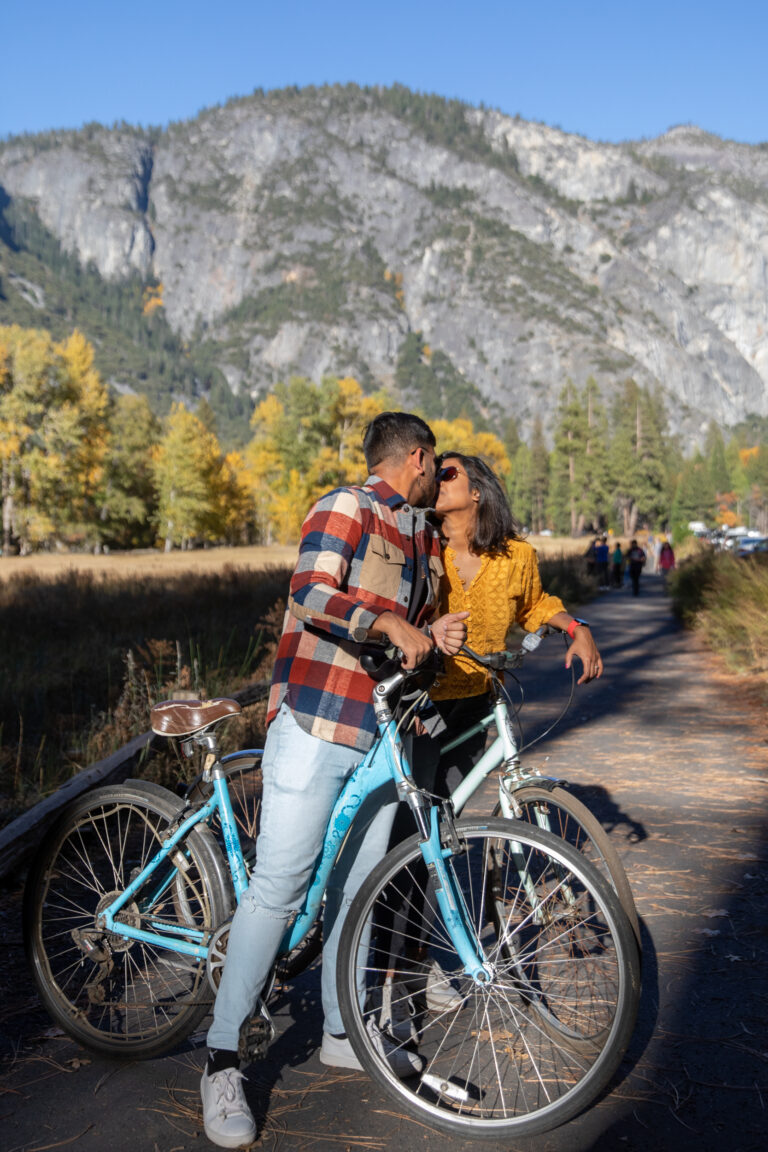 A couple kiss while straddling bikes in Yosemite National Park