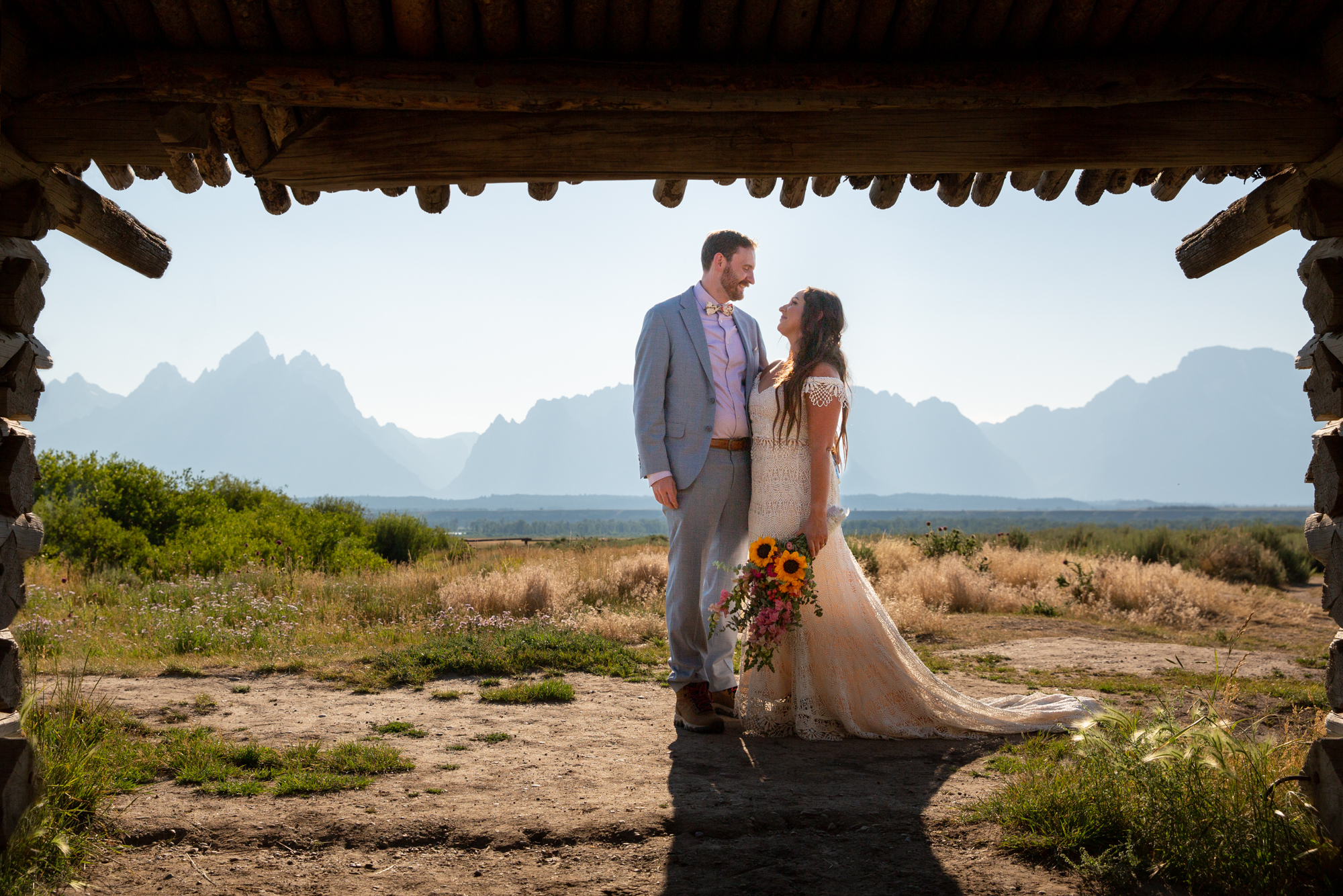 A couple stand hugging each other after eloping in Grand Teton National park.