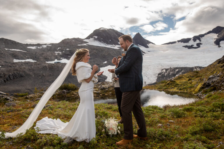 Bride and groom share their vows on top of a mountain in Alaska on their helicopter elopement day.