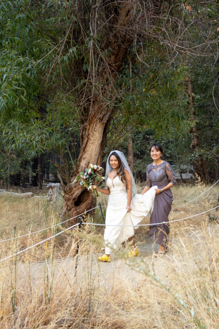 A bride walks with her mom down a makeshift isle on her intimate wedding day in Yosemite