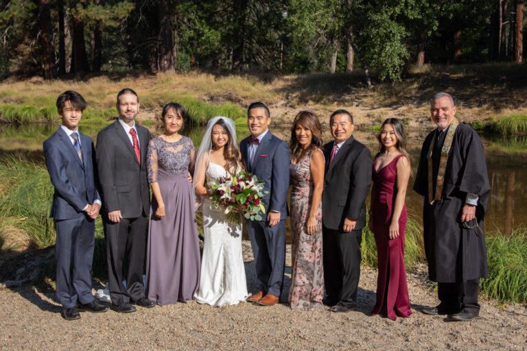 A formal portrait of a bride and groom, their families and their officiant on their intimate wedding day.