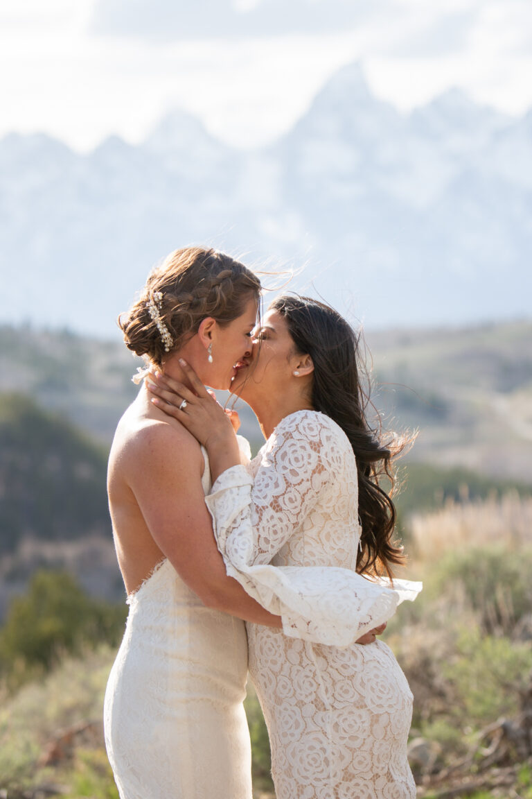Two brides share their first kiss after their elopement ceremony.