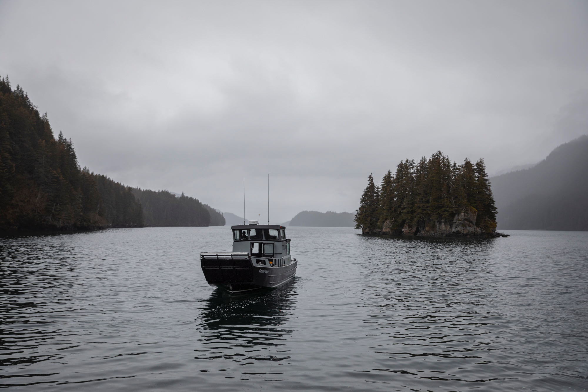 A boat is in the water of Kachemak bay after dropping a couple off on an isthmus to get married.