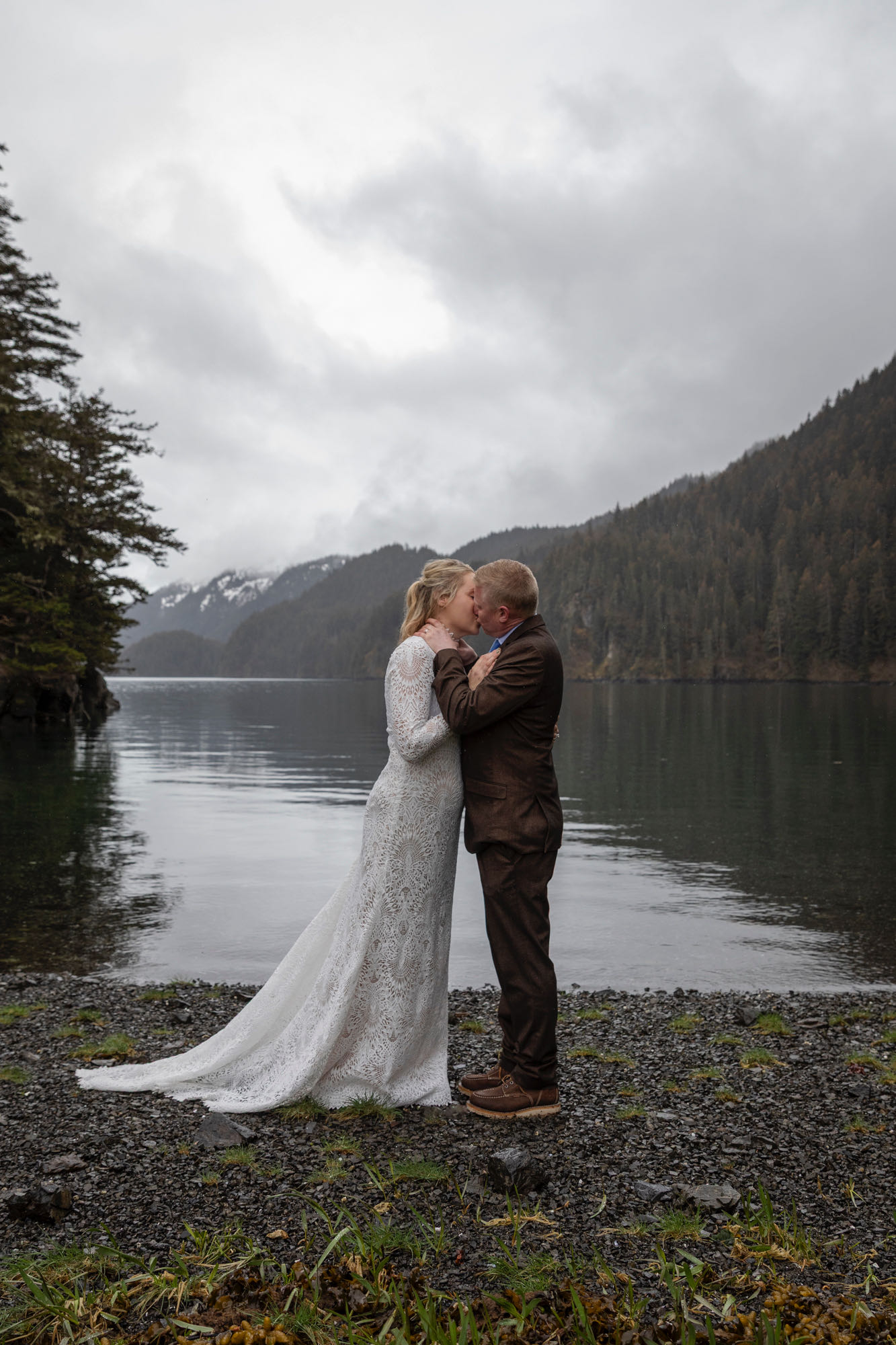 Couple sharing a kiss during Kachemak Bay elopement on overcast day in Homer Alaska