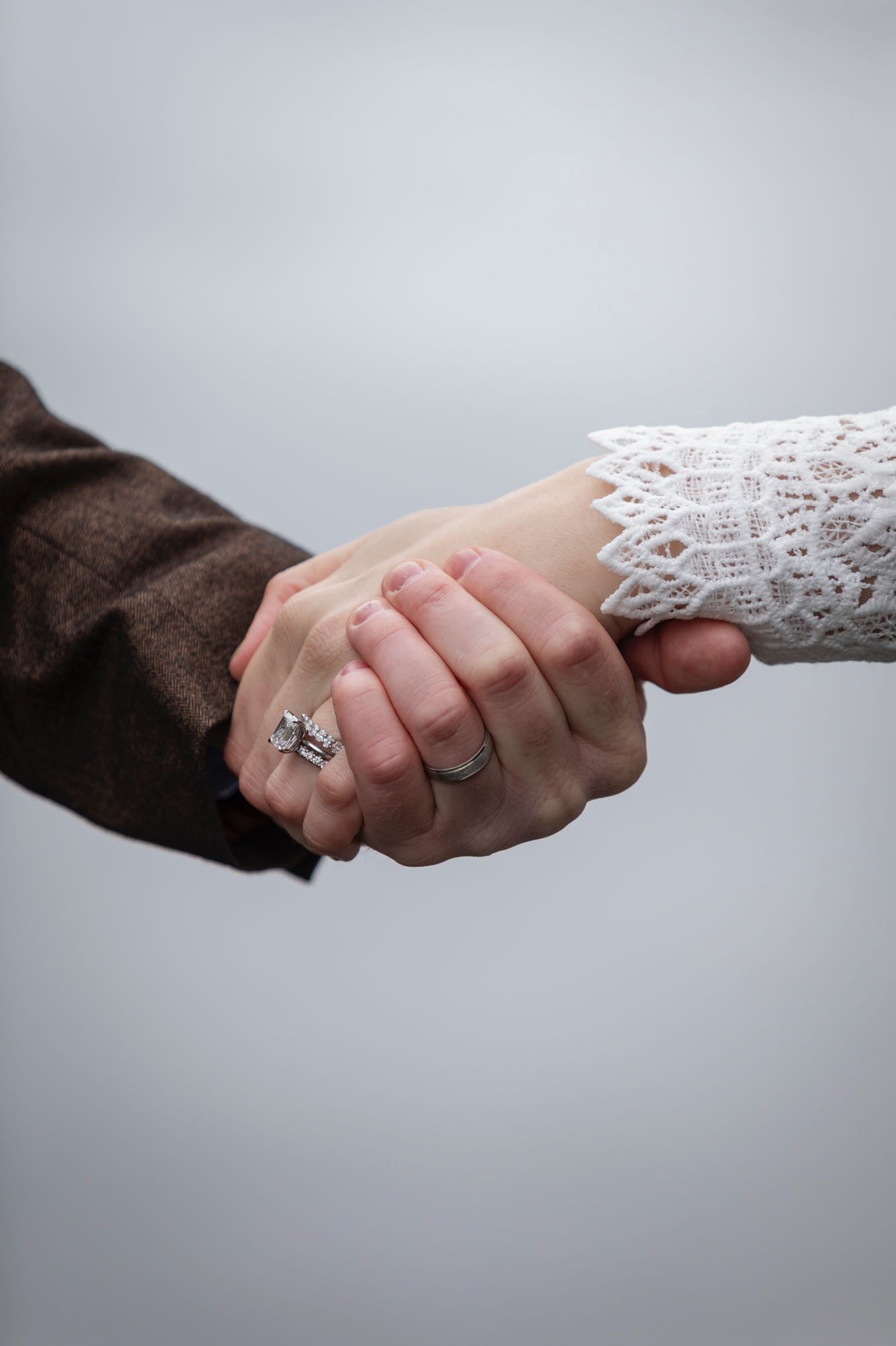 Close up of couple holding hands showing wedding rings during intimate Alaska elopement