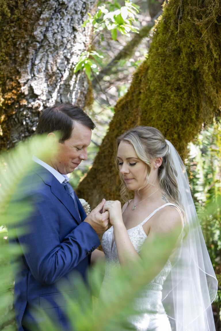 10 Breathtaking Places in California to Elope | Scenic Vows A bride and groom stand together holding up her hand, admiring her wedding ring together.