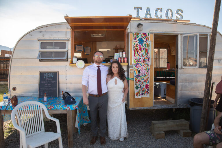 A bride and groom stand in front of a taco truck on their Stanley Idaho elopement day.
