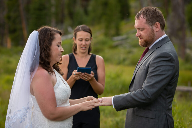 An officiant reads during a Stanley Idaho elopement ceremony as the bride and groom exchange rings.