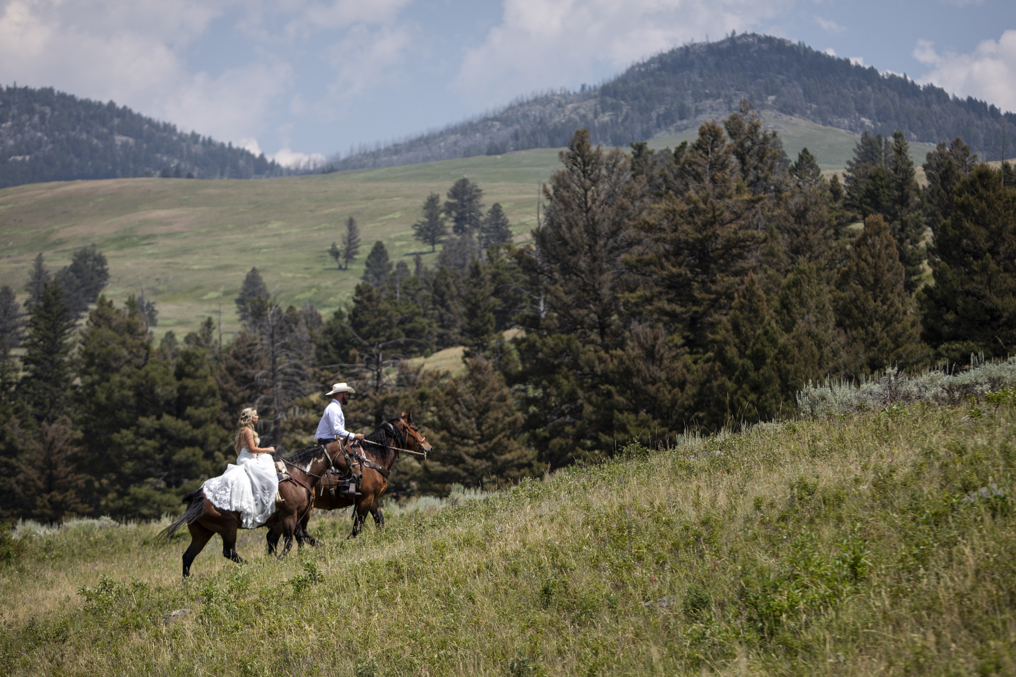 8 Incredible Places to Elope in Wyoming | Scenic Vows Bride and groom horseback riding through Yellowstone during their Wyoming elopement