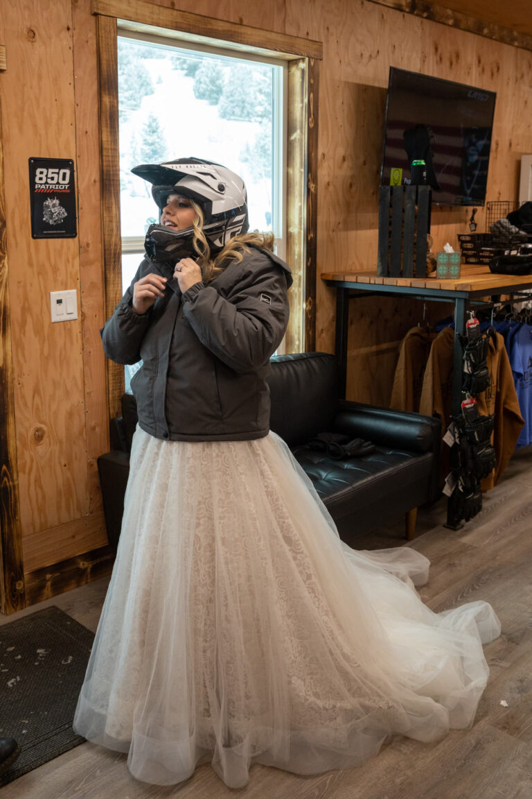 A bride wearing a helmet, buckles the strap under her chin.