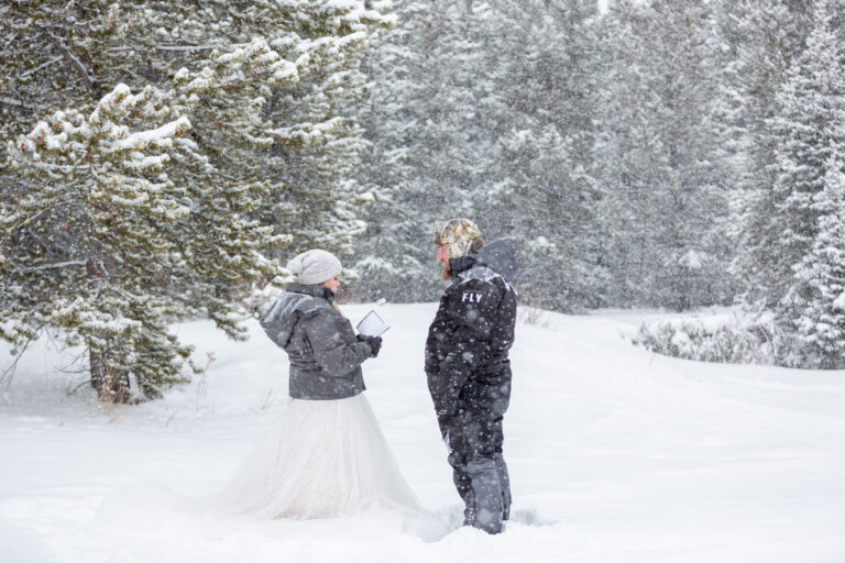 A bride reads her vows to her groom as the snow falls around them.