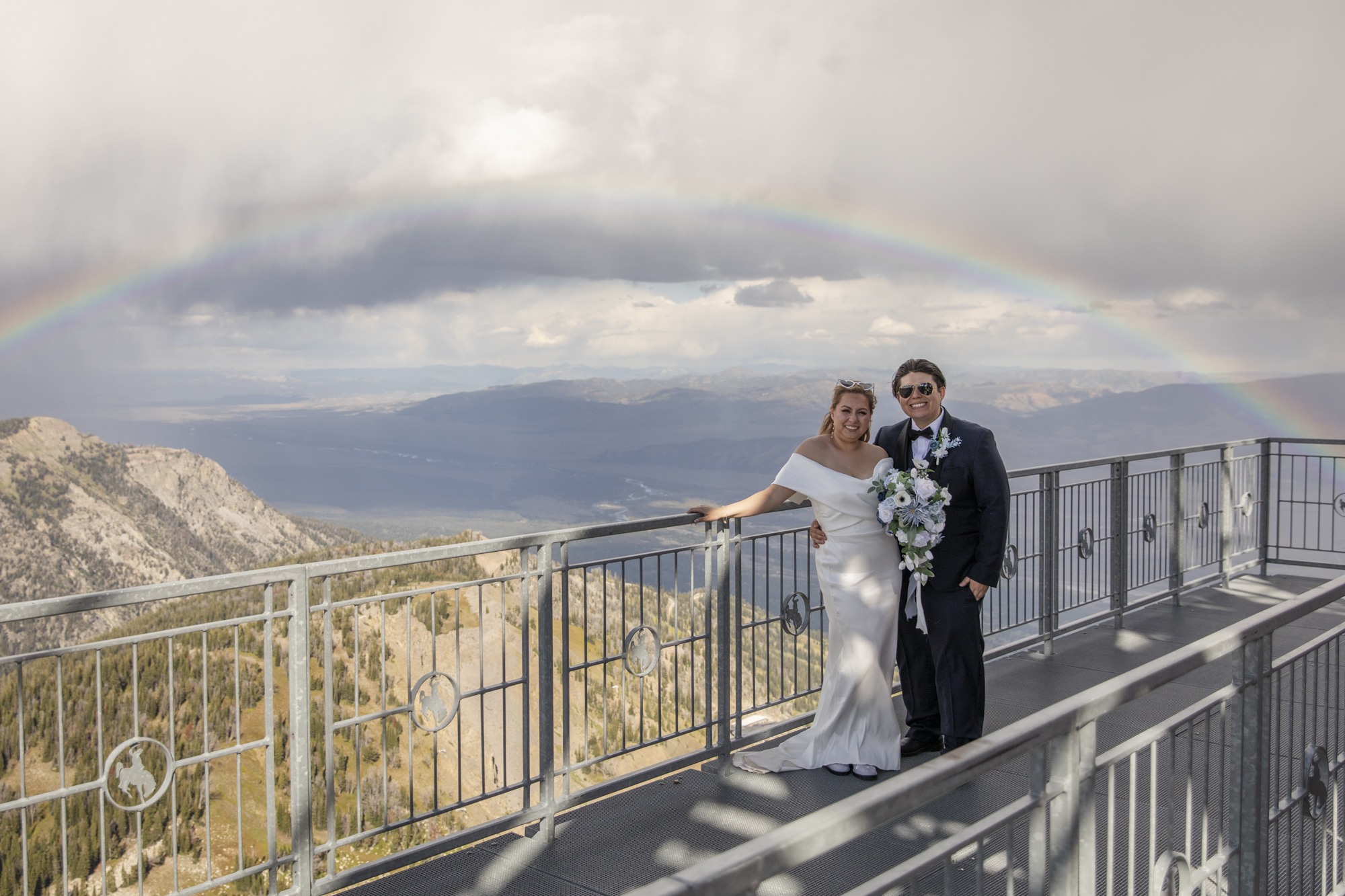 8 Incredible Places to Elope in Wyoming | Scenic Vows Newlyweds beneath a rainbow overlooking the mountains at one of the best places to get married in Wyoming