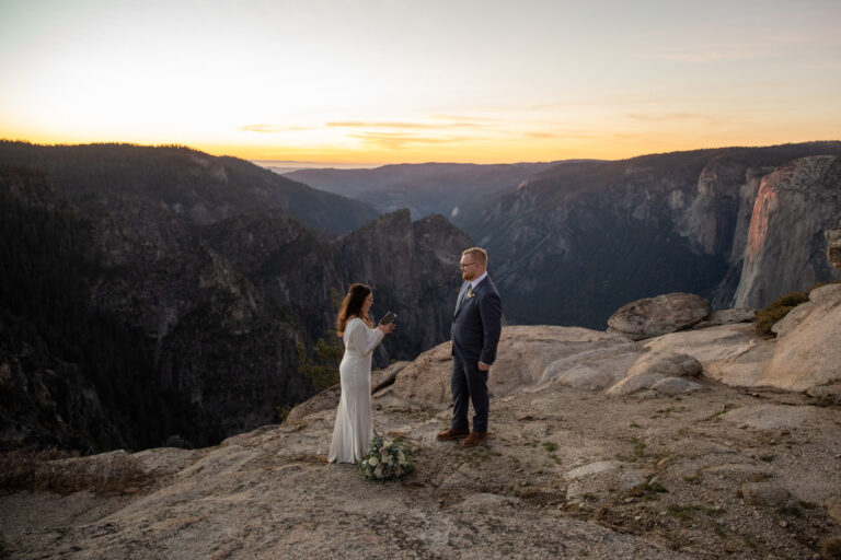 A bride reads her vows to her groom at Taft Point on their Yosemite elopement day.