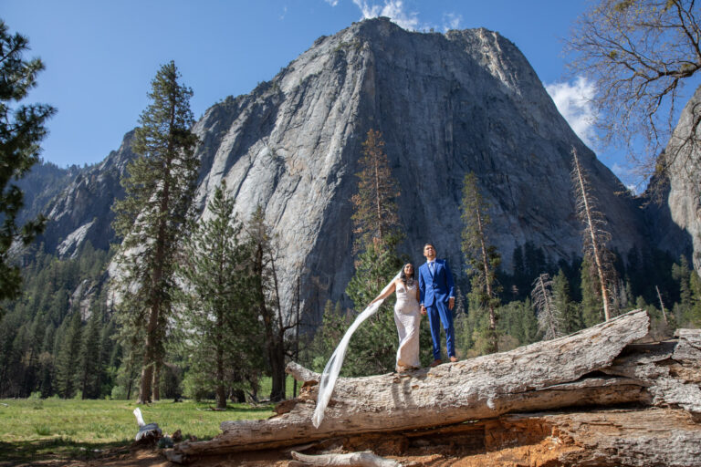 A bride and groom stand together looking up at El Capitan on their Yosemite elopement day.